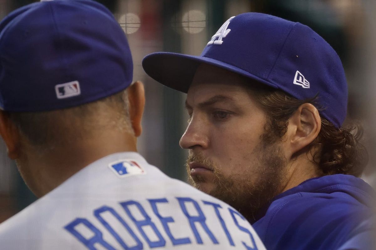 Jul 1, 2021; Washington, District of Columbia, USA; Los Angeles Dodgers starting pitcher Trevor Bauer (R) talks with Dodgers manager Dave Roberts (L) in the dugout against the Washington Nationals in the third inning at Nationals Park. Mandatory Credit: Geoff Burke-Imagn Images