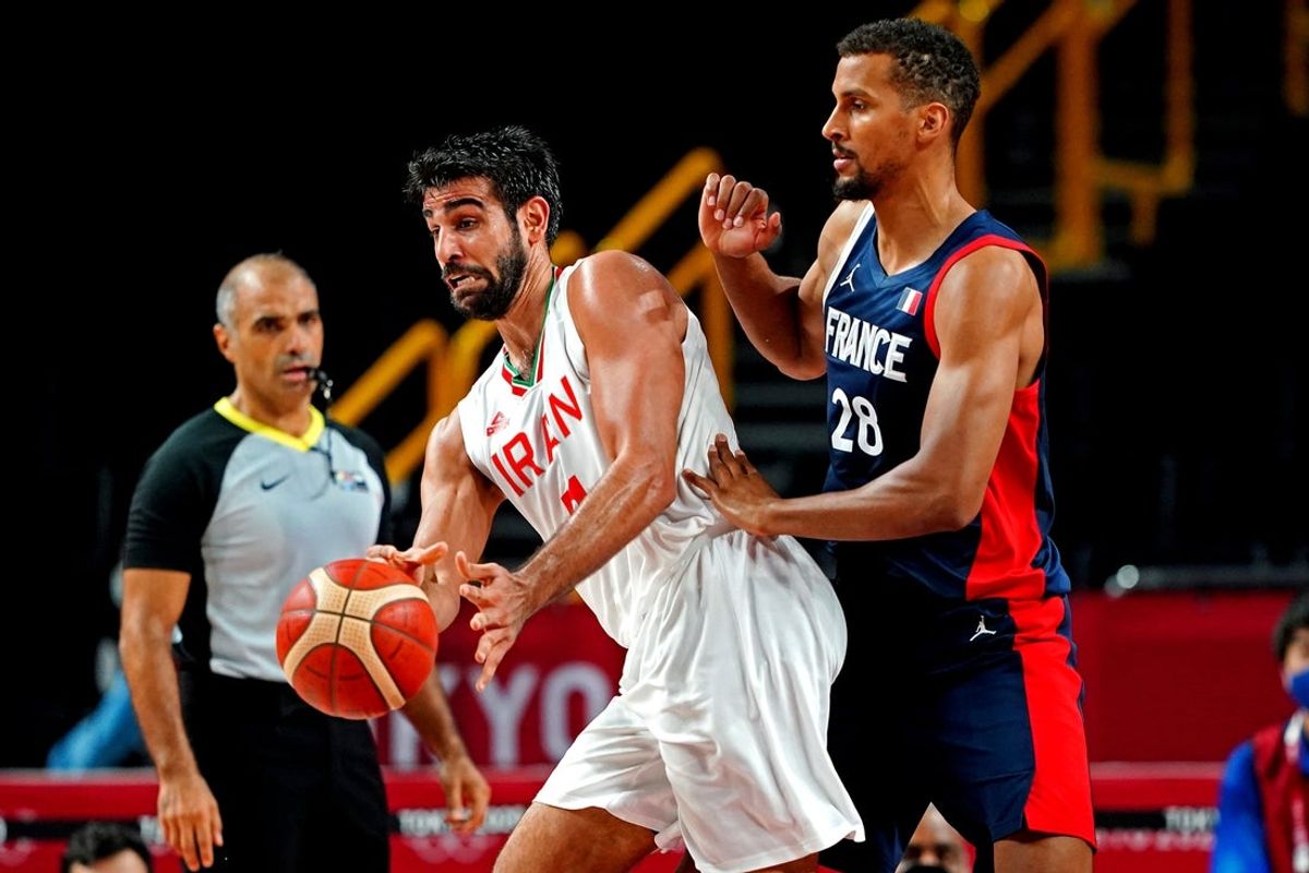 Jul 31, 2021; Saitama, Japan; Iran power forward Mohammad Hassanzadeh (7) passes the ball against France centre Petr Cornelie (28) during men's basketball group A play during the Tokyo 2020 Olympic Summer Games at Saitama Super Arena. Mandatory Credit: Kareem Elgazzar-Imagn Images