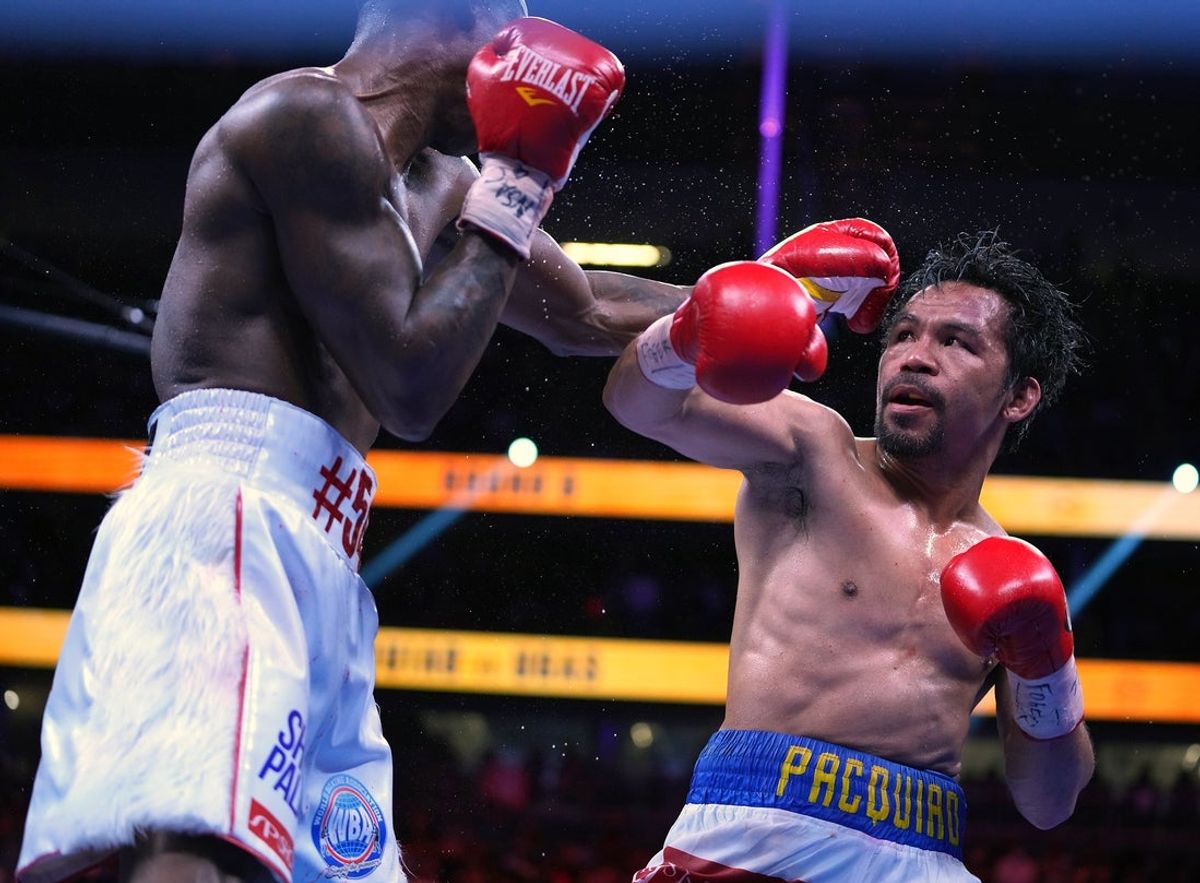 Aug 21, 2021; Las Vegas, Nevada; Manny Pacquiao (right) fights Yordenis Ugas in a world welterweight championship bout at T-Mobile Arena. Mandatory Credit: Stephen R. Sylvanie-Imagn Images