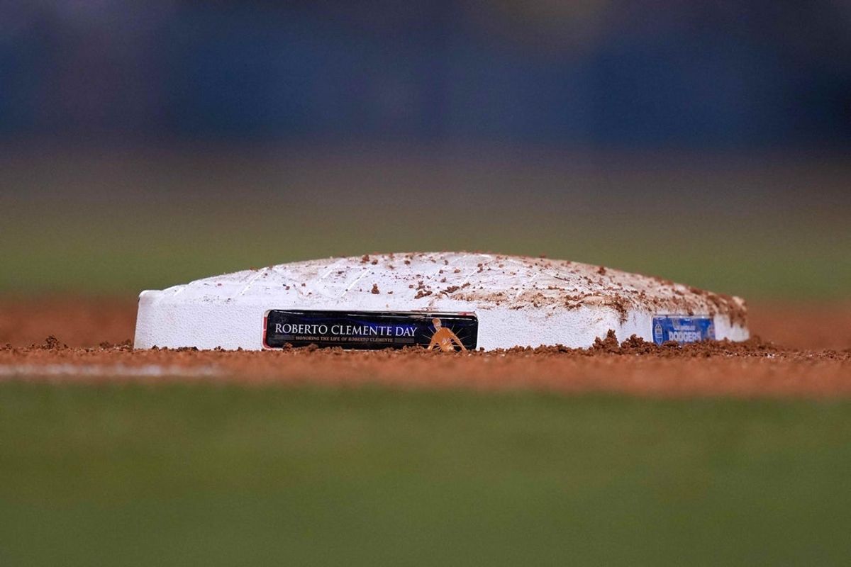 Sep 15, 2021; Los Angeles, California, USA; A detailed view of the Roberto Clemente Day logo on first base at Dodger Stadium. Mandatory Credit: Kirby Lee-Imagn Images