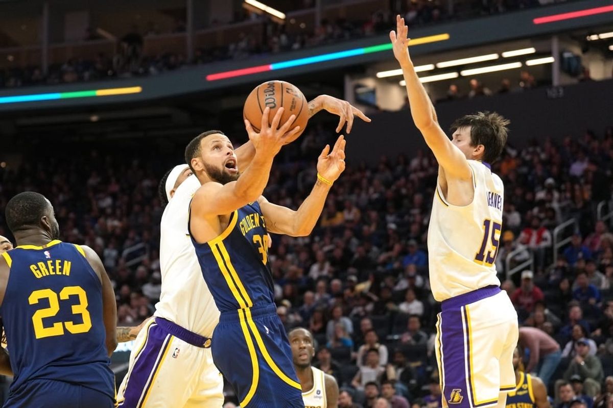 Jan 27, 2024; San Francisco, California, USA; Golden State Warriors guard Stephen Curry (center) shoots against Los Angeles Lakers forward Anthony Davis (obscured) and guard Austin Reaves (15) during the third quarter at Chase Center.