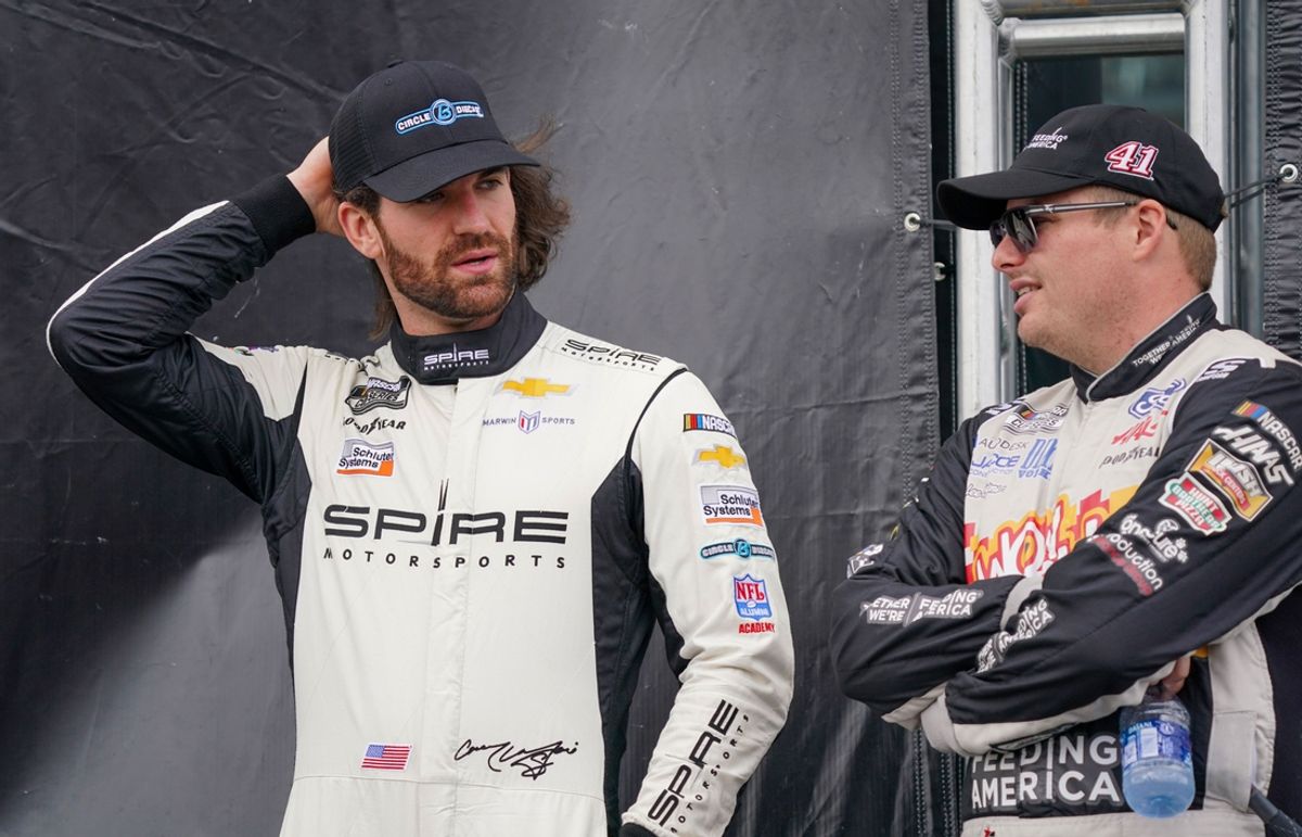 Oct 24, 2021; Kansas City, Kansas, USA; NASCAR Cup Series driver Corey LaJoie (7) talks with driver Justin Haley (77) backstage before the Hollywood Casino 400 at Kansas Speedway. Mandatory Credit: Denny Medley-Imagn Images