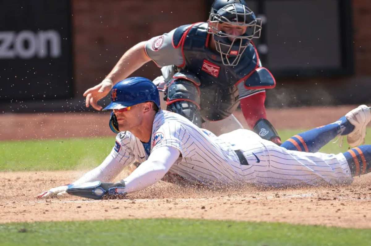 11 de julio de 2024; Ciudad de Nueva York, Nueva York, Estados Unidos; El jardinero izquierdo de los Mets de Nueva York, Brandon Nimmo (9), anota una carrera bajo la etiqueta del receptor de los nacionales de Washington, Riley Adams (15) durante la quinta entrada en Citi Field. Crédito obligatorio: Vincent Carchietta-USA TODAY Deportes