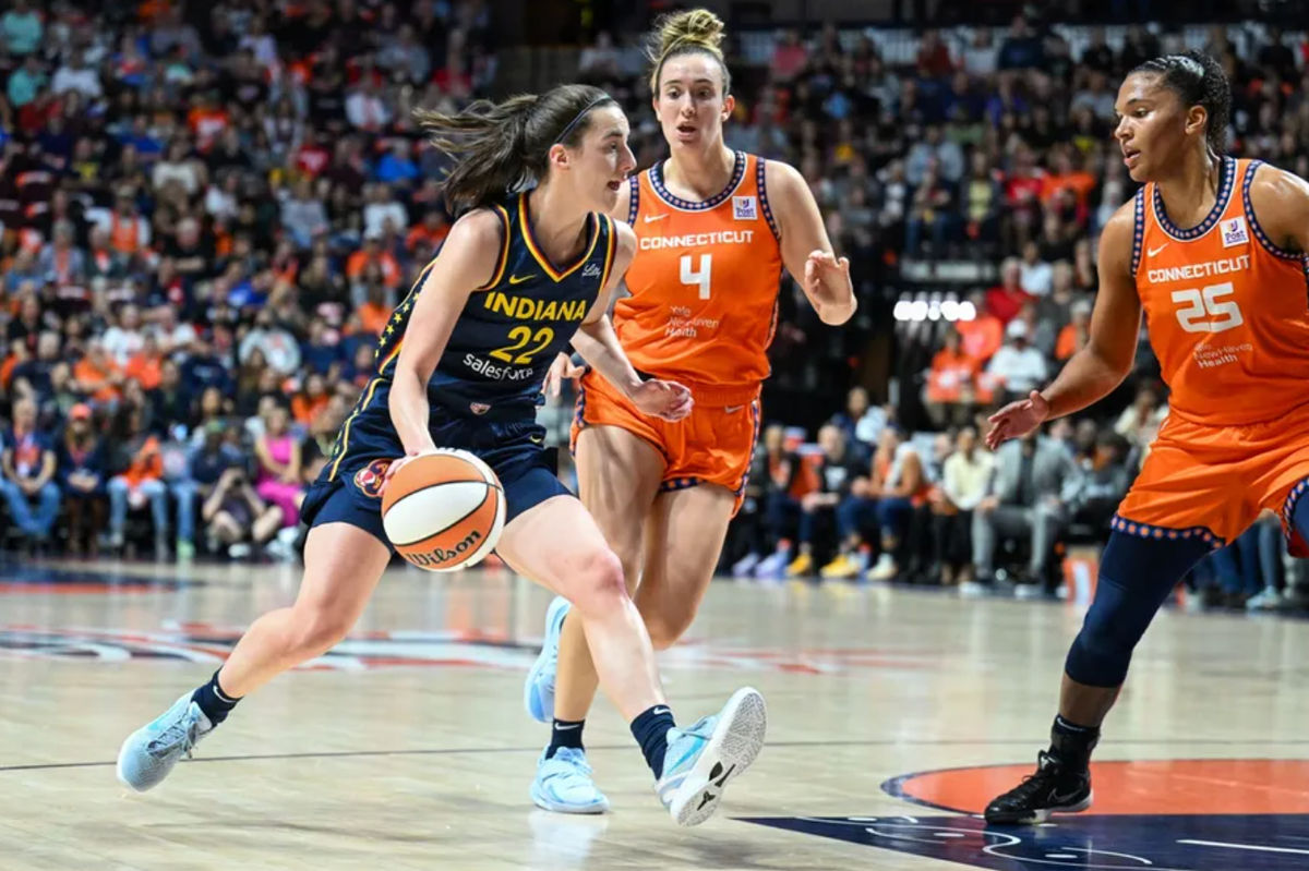 22 de setembro de 2024; Uncasville, Connecticut, EUA; A armadora do Indiana Fever Caitlin Clark (22) dribla a bola contra a atacante do Connecticut Sun Alyssa Thomas (25) e a armadora do Connecticut Sun Marina Mabrey (4) no segundo quarto durante o primeiro jogo da primeira rodada dos playoffs da WNBA de 2024 na Mohegan Sun Arena. Crédito obrigatório: Mark Smith-Imagn Images