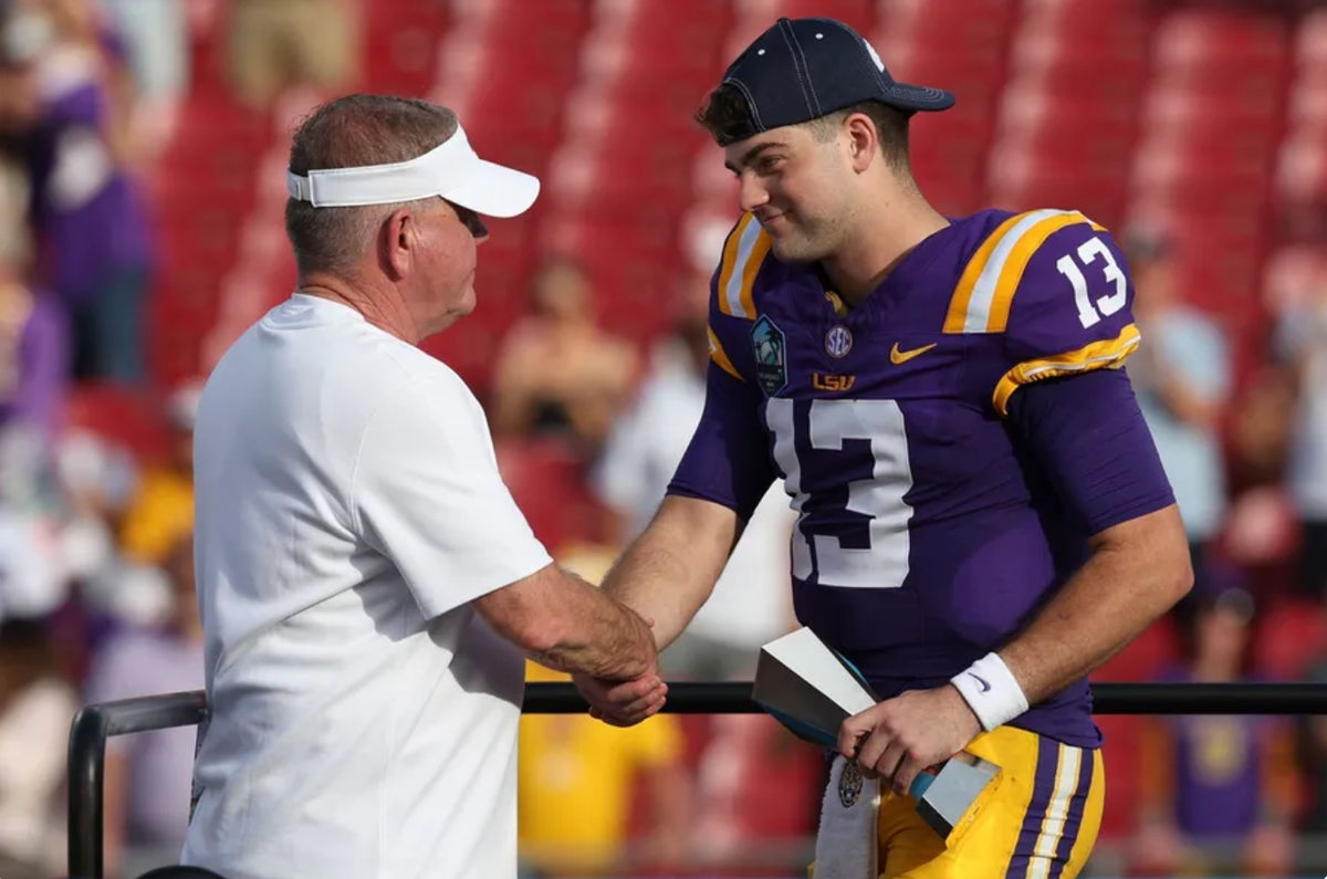Jan 1, 2024; Tampa, FL, USA; LSU Tigers quarterback Garrett Nussmeier (13) is congratulated by head coach Brian Kelly after being awarded the MVP award after beating the Wisconsin Badgers in the ReliaQuest Bowl at Raymond James Stadium. Mandatory Credit: Nathan Ray Seebeck-Imagn Images