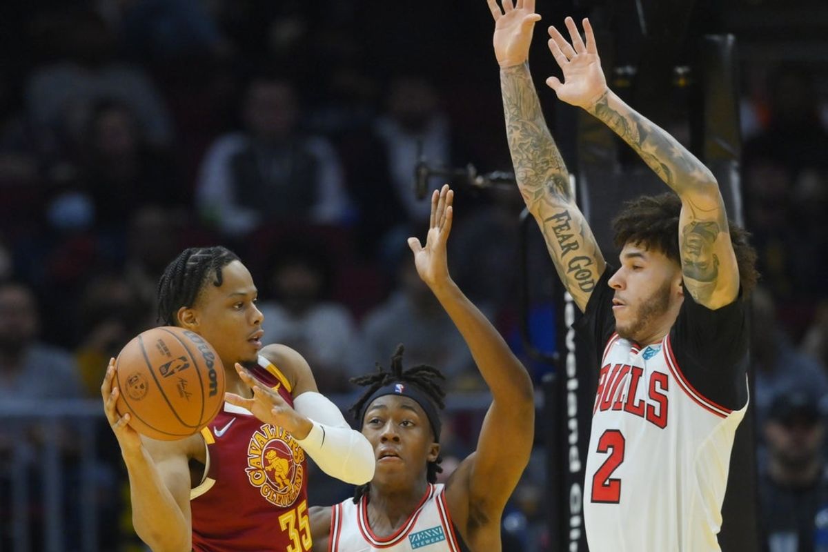 Dec 8, 2021; Cleveland, Ohio, USA; Chicago Bulls guard Ayo Dosunmu (12) and guard Lonzo Ball (2) defend Cleveland Cavaliers forward Isaac Okoro (35) in the third quarter at Rocket Mortgage FieldHouse. Mandatory Credit: David Richard-Imagn Images