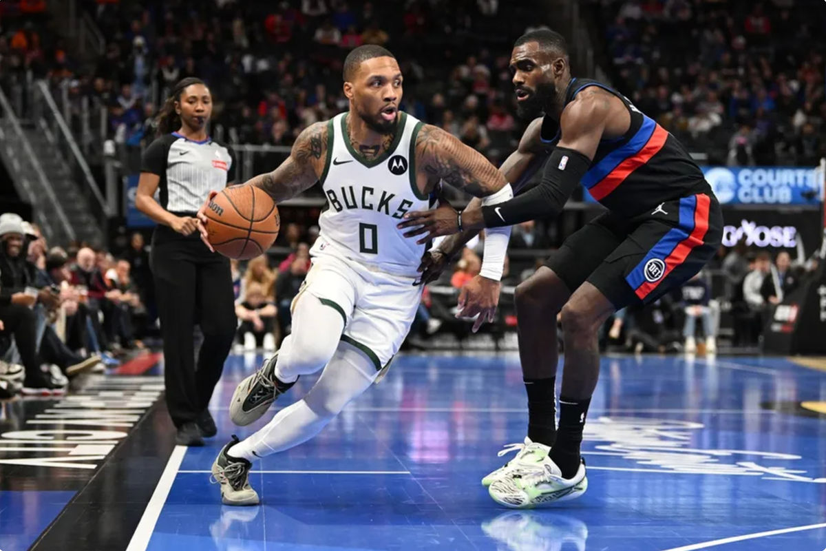 3 de diciembre de 2024; Detroit, Michigan, EE. UU.; El escolta de los Milwaukee Bucks, Damian Lillard (0), controla el balón contra el alero de los Detroit Pistons, Tim Hardaway Jr. (8), en el primer cuarto en el Little Caesars Arena. Crédito obligatorio: Lon Horwedel-Imagn Images