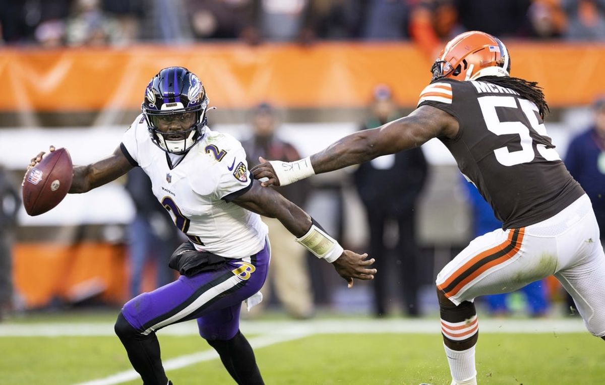 Dec 12, 2021; Cleveland, Ohio, USA; Baltimore Ravens quarterback Tyler Huntley (2) evades a tackle by Cleveland Browns defensive end Takkarist McKinley (55) during the fourth quarter at FirstEnergy Stadium. Mandatory Credit: Scott Galvin-USA TODAY Sports