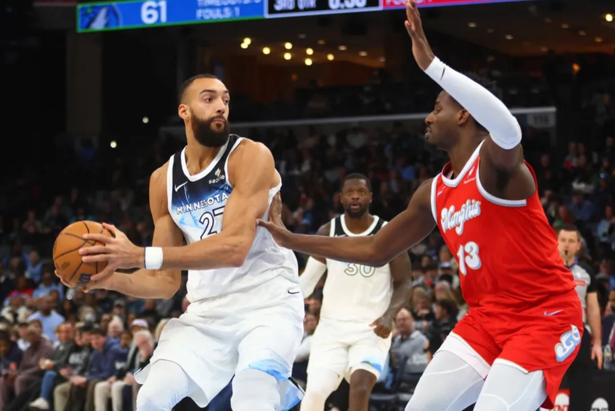 20 de janeiro de 2025; Memphis, Tennessee, EUA; O pivô do Minnesota Timberwolves, Rudy Gobert (27), avança para a cesta enquanto o atacante do Memphis Grizzlies, Jaren Jackson Jr. (13), defende durante o segundo tempo no FedExForum. Crédito obrigatório: Petre Thomas-Imagn Images