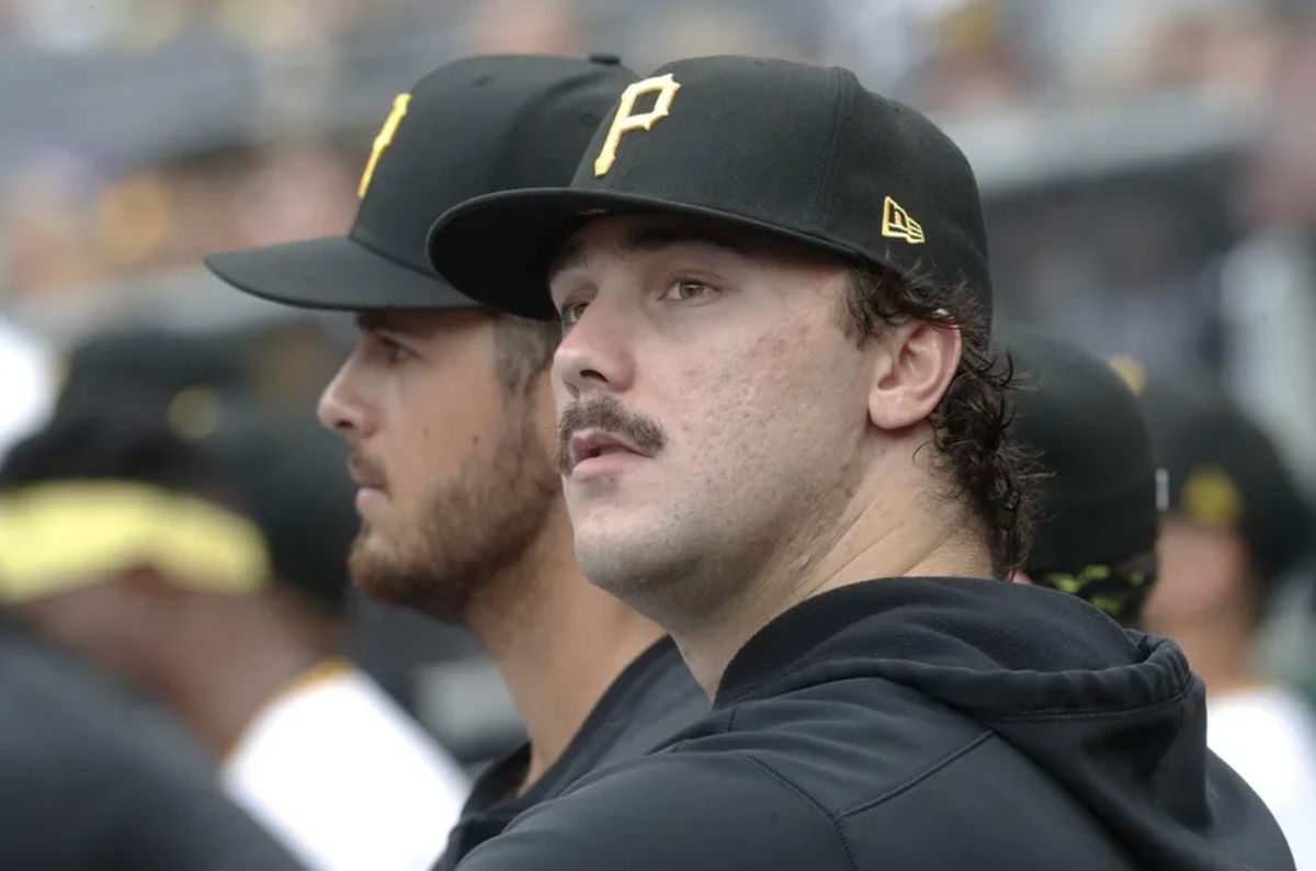 Sep 26, 2024; Pittsburgh, Pennsylvania, USA; Pittsburgh Pirates pitchers Jared Jones (left) and Paul Skenes (right) look on from the dugout against the Milwaukee Brewers during the third inning at PNC Park. Mandatory Credit: Charles LeClaire-Imagn Images