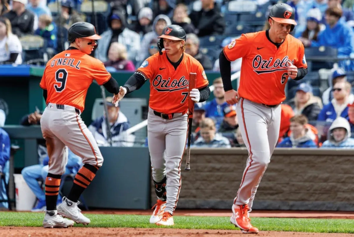 Apr 5, 2025; Kansas City, Missouri, USA; Baltimore Orioles second baseman Jackson Holliday (7) reacts with Baltimore Orioles outfielder Tyler O'Neill (9) and first baseman Ryan Mountcastle (6) after scoring during the second inning against the Kansas City Royals at Kauffman Stadium. Mandatory Credit: William Purnell-Imagn Images