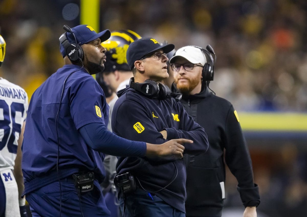 Dec 4, 2021; Indianapolis, IN, USA; Michigan Wolverines offensive line coach Sherrone Moore (left), head coach Jim Harbaugh (center) and special teams coordinator Jay Harbaugh against the Iowa Hawkeyes in the Big Ten Conference championship game at Lucas Oil Stadium. Mandatory Credit: Mark J. Rebilas-Imagn Images