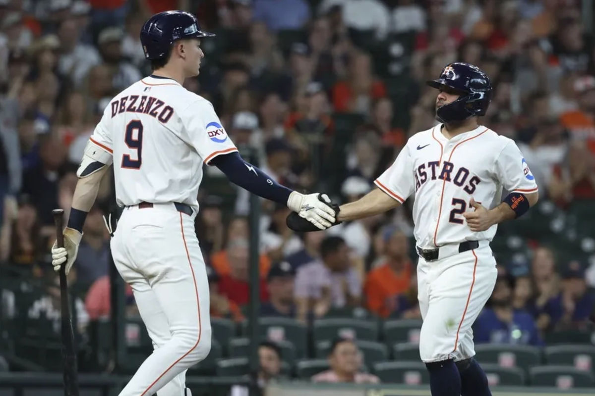 10 de mayo de 2025; Houston, Texas, EE. UU.; El segunda base de los Astros de Houston, José Altuve (27), celebra con el jardinero izquierdo Zach Dezenzo (9) tras anotar una carrera en la primera entrada contra los Rojos de Cincinnati en el Daikin Park. Crédito obligatorio: Troy Taormina-Imagn Images