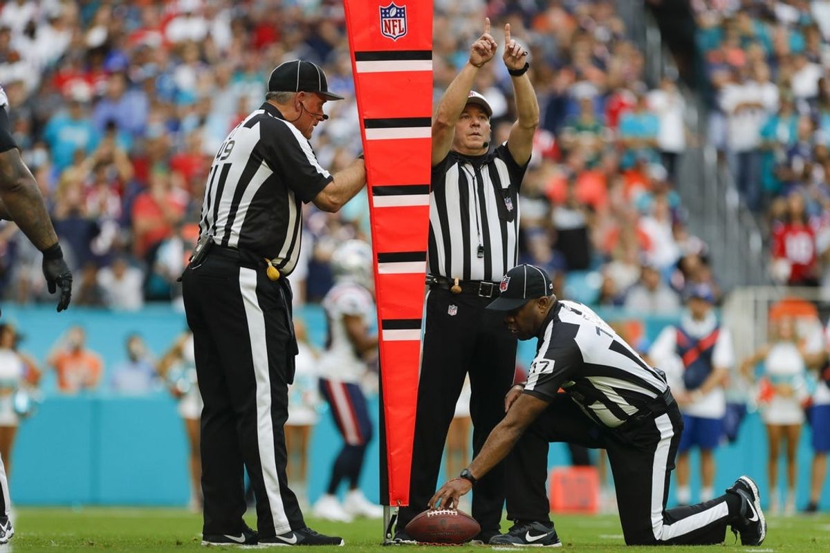 Jan 9, 2022; Miami Gardens, Florida, USA; Game officials measure the distance to a first down in the first quarter of the game between the Miami Dolphins and the New England Patriots at Hard Rock Stadium. Mandatory Credit: Sam Navarro-Imagn Images