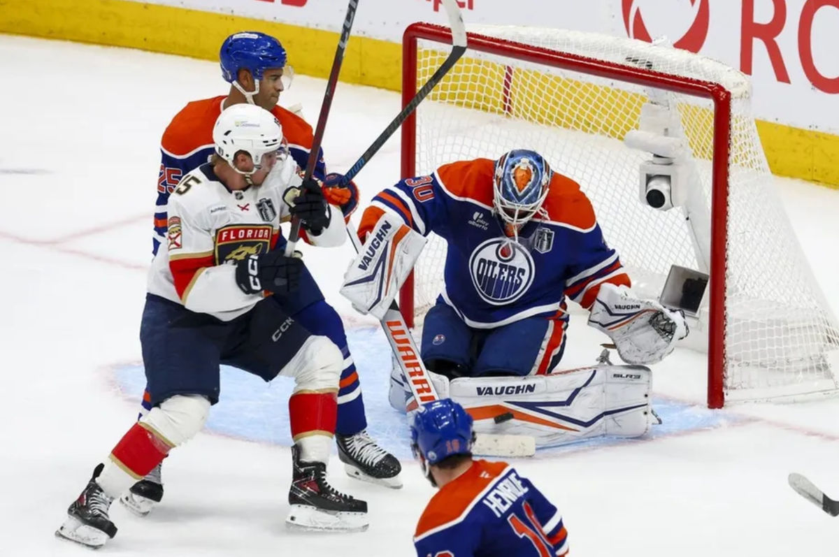 14 de junio de 2025; Edmonton, Alberta, Canadá; El portero de los Edmonton Oilers, Calvin Pickard (30), defiende al delantero de los Florida Panthers, Anton Lundell (15), durante el tercer periodo del quinto partido de la final de la Copa Stanley 2025 en el Rogers Place. Crédito obligatorio: Sergei Belski-Imagn Images