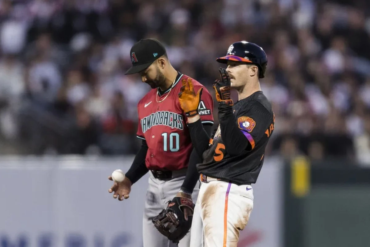 13 de mayo de 2025; San Francisco, California, EE. UU.; El campocorto de los Diamondbacks de Arizona, Jordan Lawlar (10), lanza la pelota mientras el jardinero derecho de los Gigantes de San Francisco, Mike Yastrzemski (5), reacciona tras conectar un doblete durante la cuarta entrada en el Oracle Park. Crédito obligatorio: John Hefti-Imagn Images.