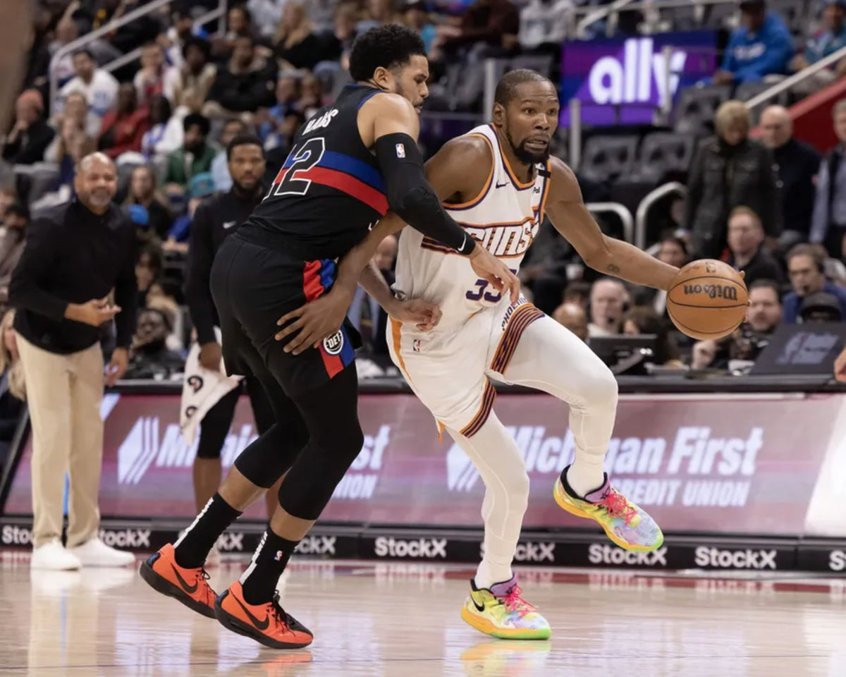 18 de enero de 2025; Detroit, Michigan, EE. UU.; El alero de los Detroit Pistons, Tobias Harris (12), defiende la posesión del balón contra el alero de los Phoenix Suns, Kevin Durant (35), durante el último cuarto en el Little Caesars Arena. Crédito obligatorio: David Reginek-Imagn Images