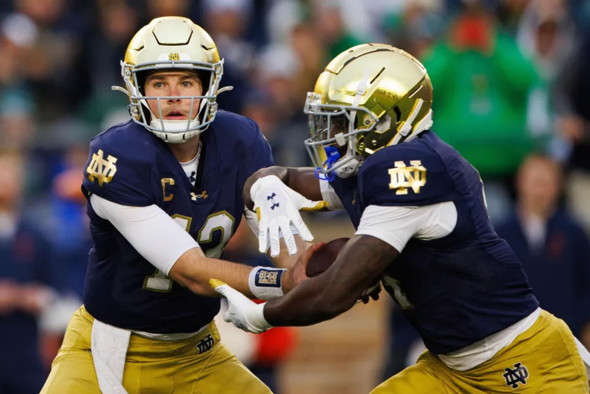 O quarterback de Notre Dame, Riley Leonard (13), passa a bola para o running back Jeremiyah Love (4) durante uma partida de futebol americano universitário da NCAA contra a Virgínia no Estádio de Notre Dame no sábado, 16 de novembro de 2024, em South Bend. FOTO: USA TODAY SPORTS IMAGES