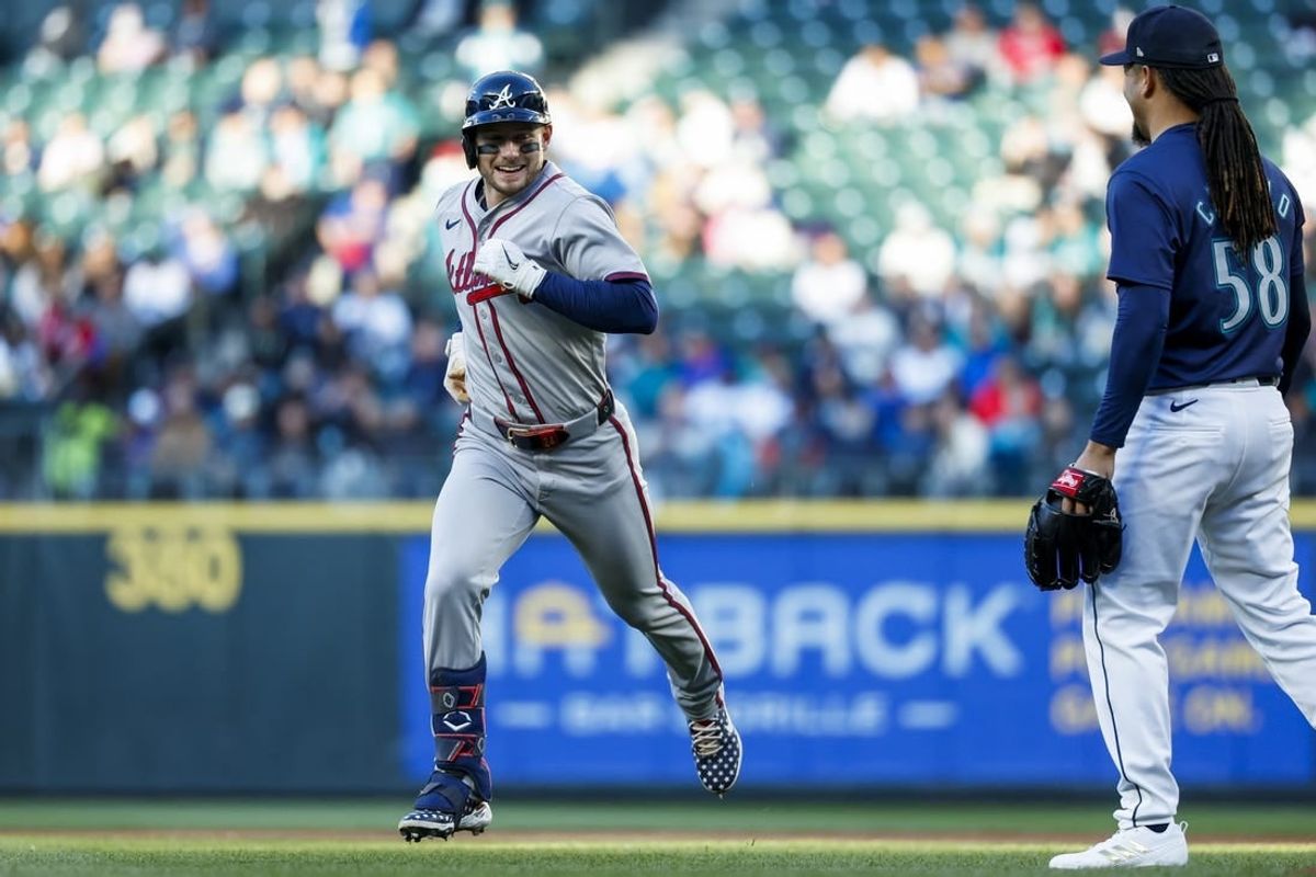 Apr 30, 2024; Seattle, Washington, USA; Atlanta Braves left fielder Jarred Kelenic (24) smiles while jogging past Seattle Mariners starting pitcher Luis Castillo (58) after hitting a fly-out during the third inning at T-Mobile Park.