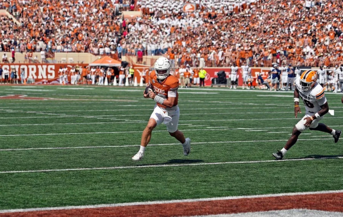 13 de septiembre de 2025; Austin, Texas, EE. UU.; El mariscal de campo de los Texas Longhorns, Arch Manning (16), mantiene el balón mientras corre para un touchdown, superando al linebacker de los Texas El Paso Miners, Micah Davey (48), durante la primera mitad en el Estadio Darrell K Royal-Texas Memorial. Crédito obligatorio: Scott Wachter-Imagn Images