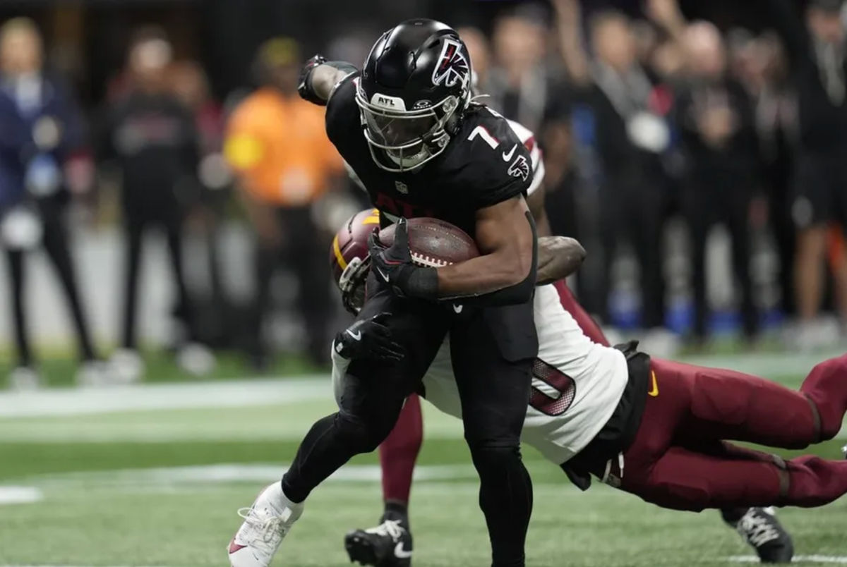 28 de septiembre de 2025; Atlanta, Georgia, EE. UU.; El corredor de los Atlanta Falcons, Bijan Robinson (7), anota un touchdown contra el esquinero de los Washington Commanders, Mike Sainristil (0), durante la primera mitad en el Mercedes-Benz Stadium. Crédito obligatorio: Dale Zanine-Imagn Images.