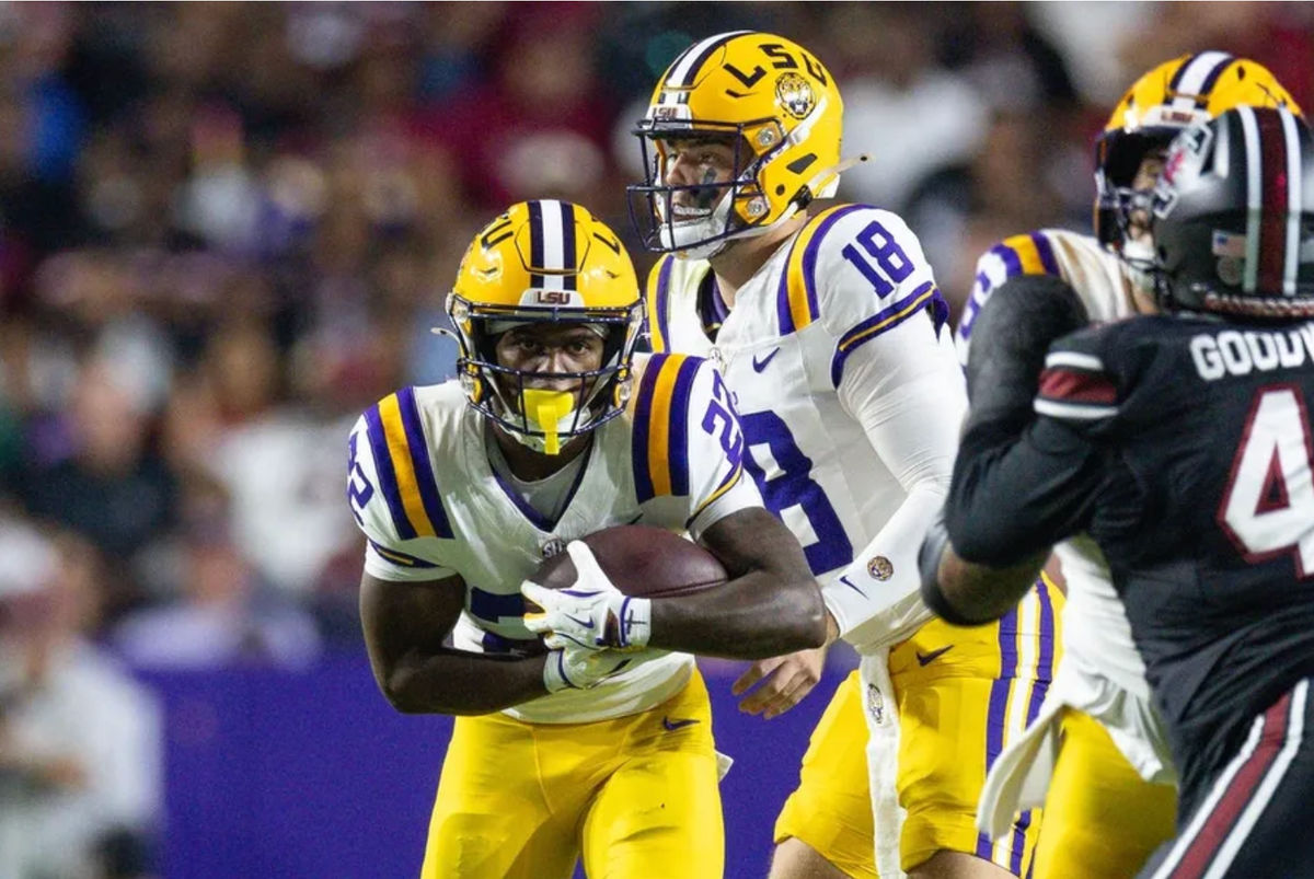 11 de octubre de 2025; Baton Rouge, Luisiana, EE. UU.; El mariscal de campo de los LSU Tigers, Garrett Nussmeier (18), entrega el balón al corredor Harlem Berry (22) contra los South Carolina Gamecocks durante la primera mitad en el Tiger Stadium. Crédito obligatorio: Stephen Lew-Imagn Images