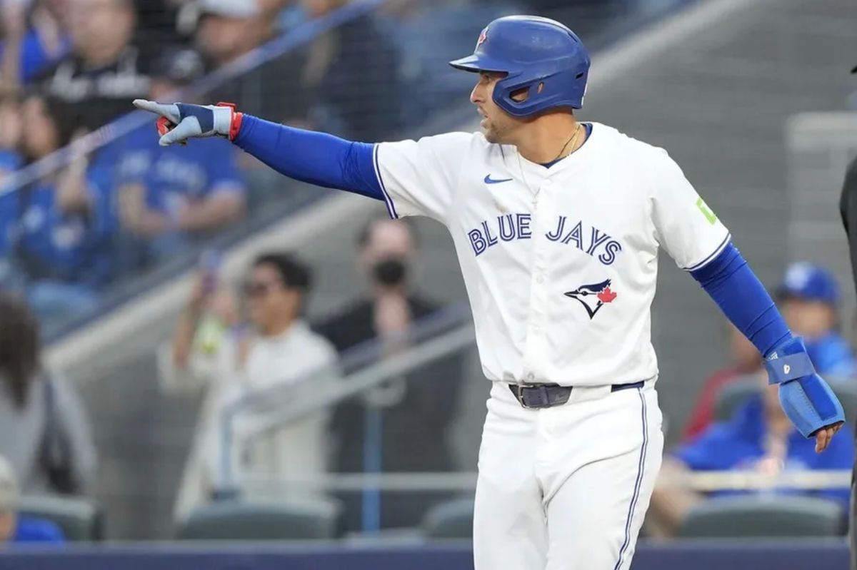 25 de agosto de 2025; Toronto, Ontario, Canadá; El jardinero izquierdo de los Toronto Blue Jays, George Springer (4), le hace un gesto al campocorto Bo Bichette (no aparece en la foto) tras anotar con su sencillo contra los Minnesota Twins durante la primera entrada en el Rogers Centre. Crédito obligatorio: John E. Sokolowski-Imagn Images.