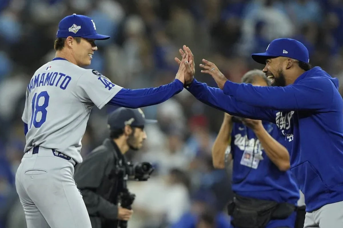 25 de octubre de 2025; Toronto, Ontario, Canadá; El lanzador de los Dodgers de Los Ángeles, Yoshinobu Yamamoto (18), celebra con el jardinero derecho Teoscar Hernández (37) tras derrotar a los Azulejos de Toronto en el segundo partido de la Serie Mundial de la MLB 2025 en el Rogers Centre. Crédito obligatorio: John E. Sokolowski-Imagn Images