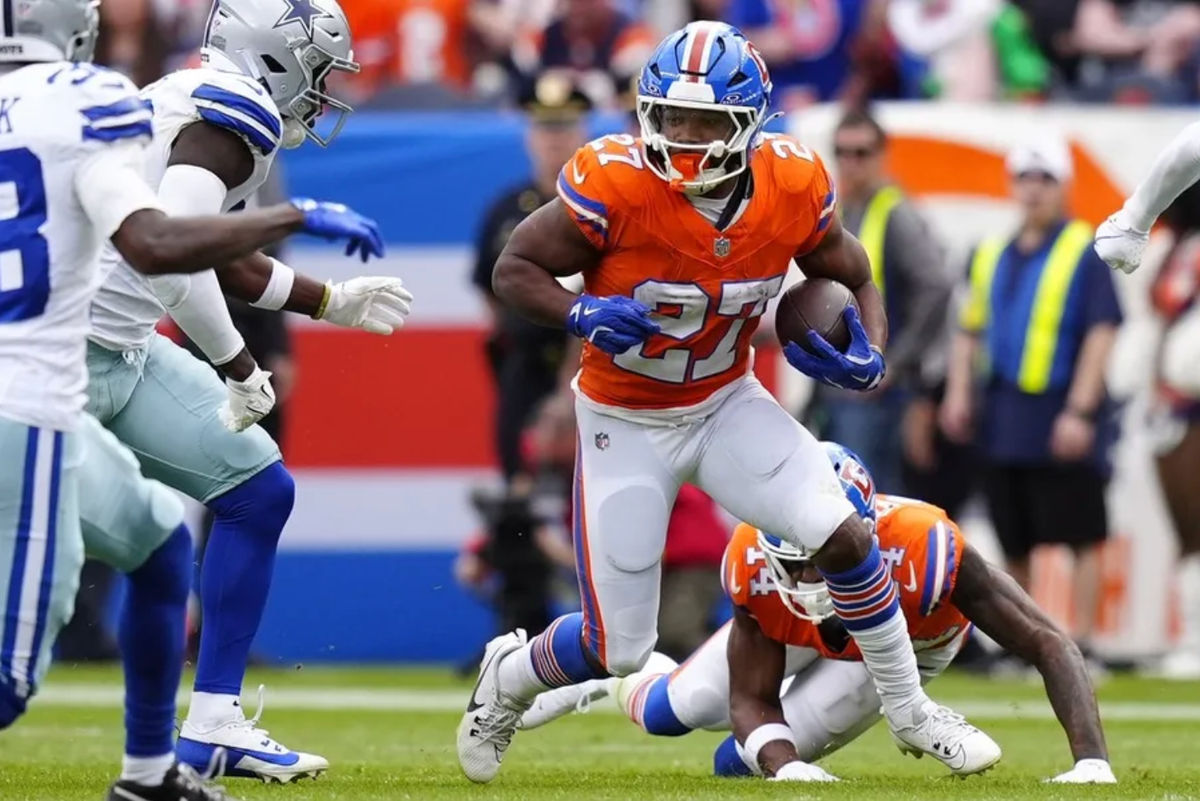 26 de outubro de 2025; Denver, Colorado, EUA; O running back do Denver Broncos, J.K. Dobbins (27), corre contra o Dallas Cowboys no primeiro tempo no Empower Field at Mile High. Crédito obrigatório: Ron Chenoy-Imagn Images