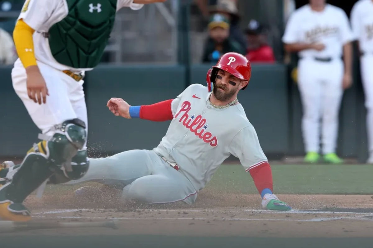 May 24, 2025; West Sacramento, California, USA; Philadelphia Phillies first baseman Bryce Harper (3) slides into home on a double hit by Nick Castellanos (8) against the Athletics during the first inning at Sutter Health Park. Mandatory Credit: Dennis Lee-Imagn Images