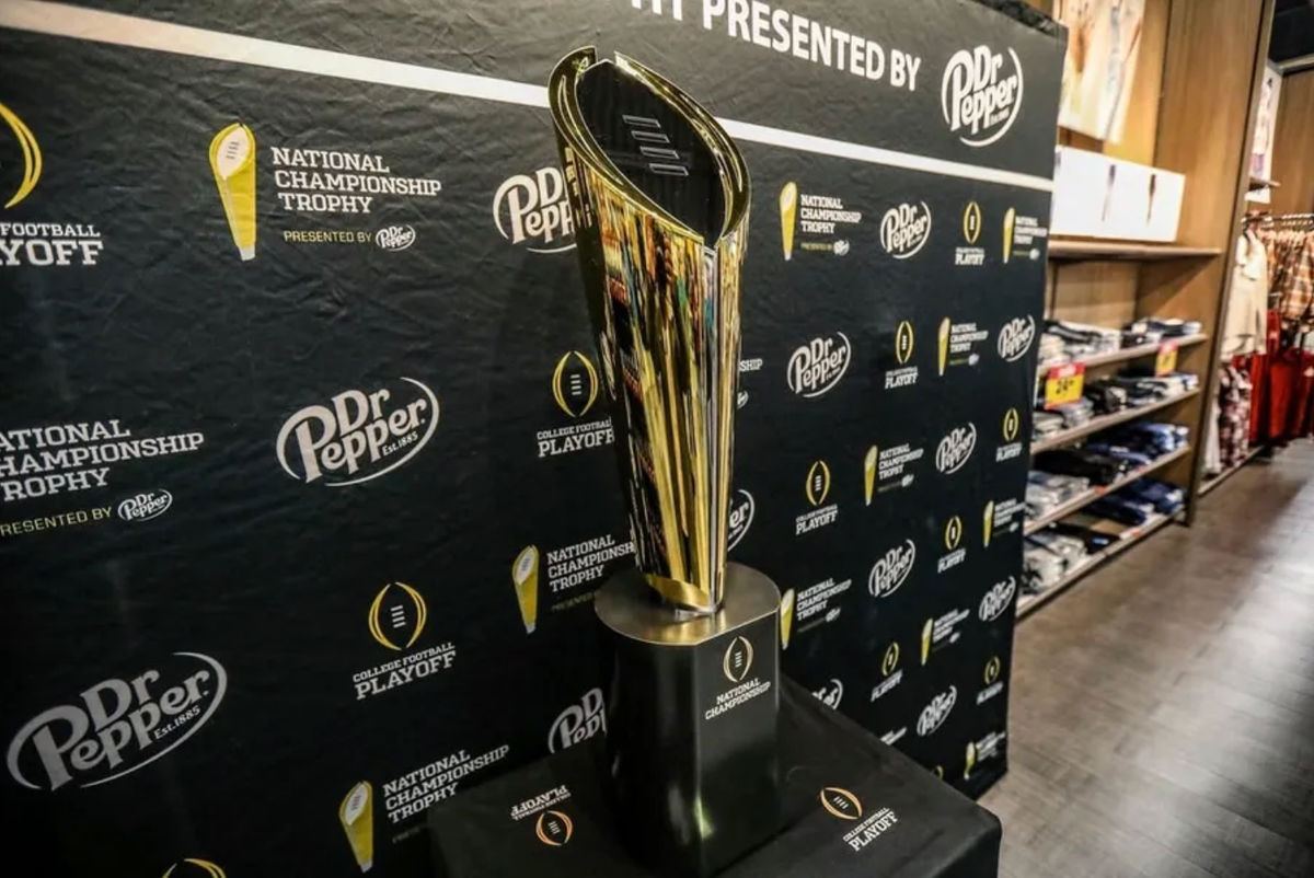 Fãs param para tirar fotos com o troféu do Campeonato Nacional de Futebol Americano Universitário no supermercado Meijer em Ypsilanti, Michigan, na quinta-feira, 11 de janeiro de 2024. O troféu está em turnê para que os fãs possam vê-lo, apresentado pela Dr. Pepper. Créditos: Kimberly P. Mitchell / USA TODAY NETWORK