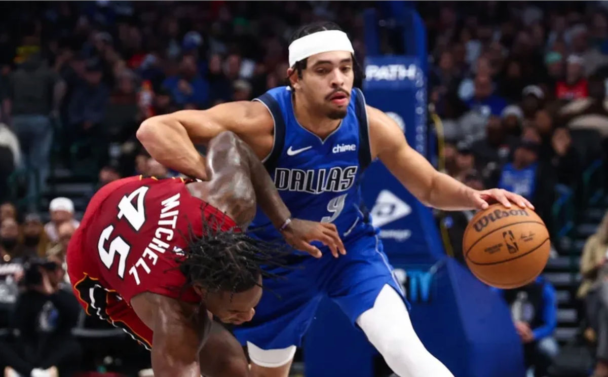 3 de dezembro de 2025; Dallas, Texas, EUA; O armador do Dallas Mavericks, Ryan Nembhard (9), controla a bola enquanto o armador do Miami Heat, Davion Mitchell (45), defende durante o primeiro tempo no American Airlines Center. Crédito obrigatório: Kevin Jairaj-Imagn Images