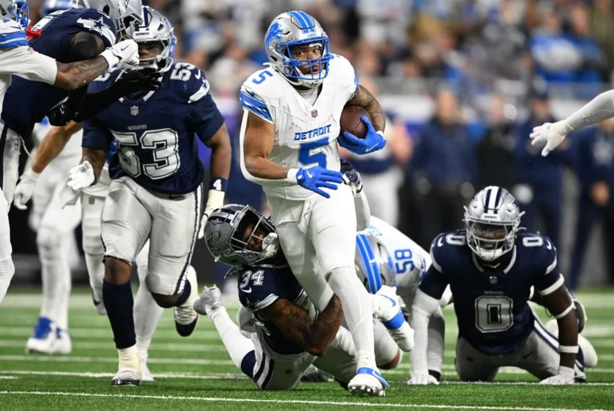 4 de dezembro de 2025; Detroit, Michigan, EUA; O running back do Detroit Lions, David Montgomery (5), corre contra o cornerback do Dallas Cowboys, Shavon Revel Jr. (34), durante o primeiro tempo no Ford Field. Crédito obrigatório: Lon Horwedel-Imagn Images