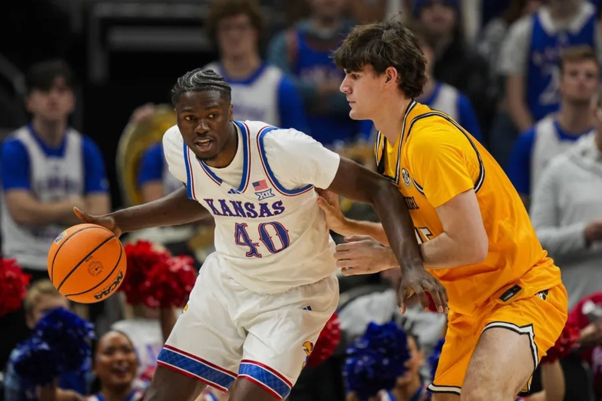 7 de dezembro de 2025; Kansas City, Missouri, EUA; O ala do Kansas Jayhawks, Flory Bidunga (40), dribla a bola contra o ala do Missouri Tigers, Luke Northweather (45), durante o segundo tempo no T-Mobile Center. Crédito obrigatório: Jay Biggerstaff-Imagn Images