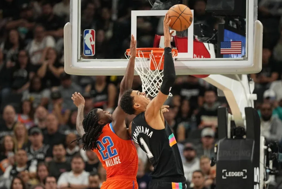 23 de dezembro de 2025; San Antonio, Texas, EUA; O ala do San Antonio Spurs, Victor Wembanyama (1), tenta interceptar um passe à frente do armador do Oklahoma City Thunder, Cason Wallace (22), durante o segundo tempo no Frost Bank Center. Crédito obrigatório: Scott Wachter-Imagn Images