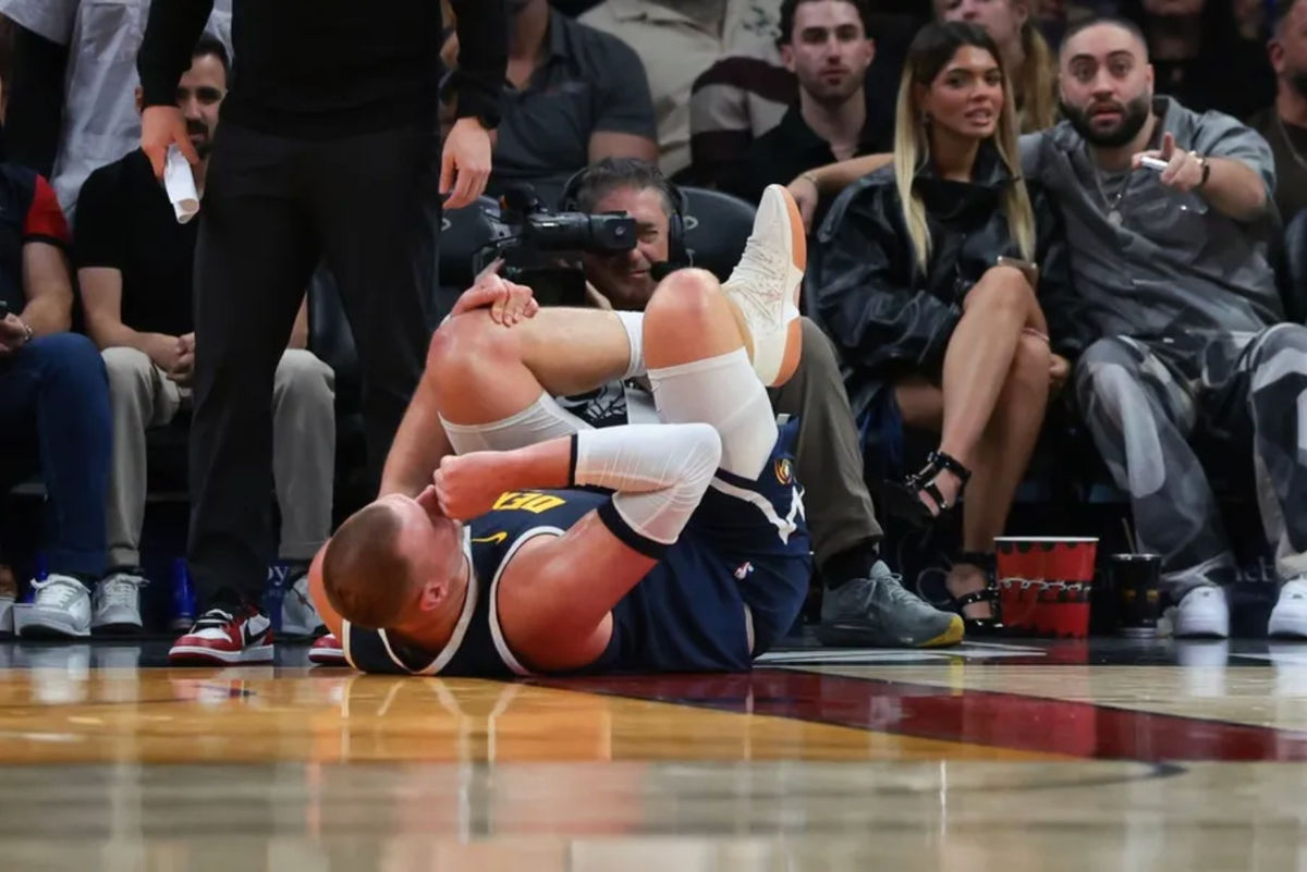 29 de diciembre de 2025; Miami, Florida, EE. UU.; El pívot de los Denver Nuggets, Nikola Jokic (15), se sujeta la rodilla tras lesionarse contra los Miami Heat durante el segundo cuarto en el Kaseya Center. Crédito obligatorio: Sam Navarro-Imagn Images