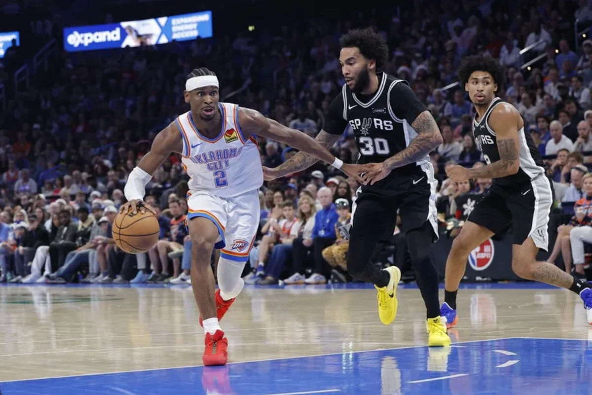 Dec 25, 2025; Oklahoma City, Oklahoma, USA; Oklahoma City Thunder guard Shai Gilgeous-Alexander (2) drives around San Antonio Spurs forward Julian Champagnie (30) during the second half at Paycom Center. Mandatory Credit: Alonzo Adams-Imagn Images