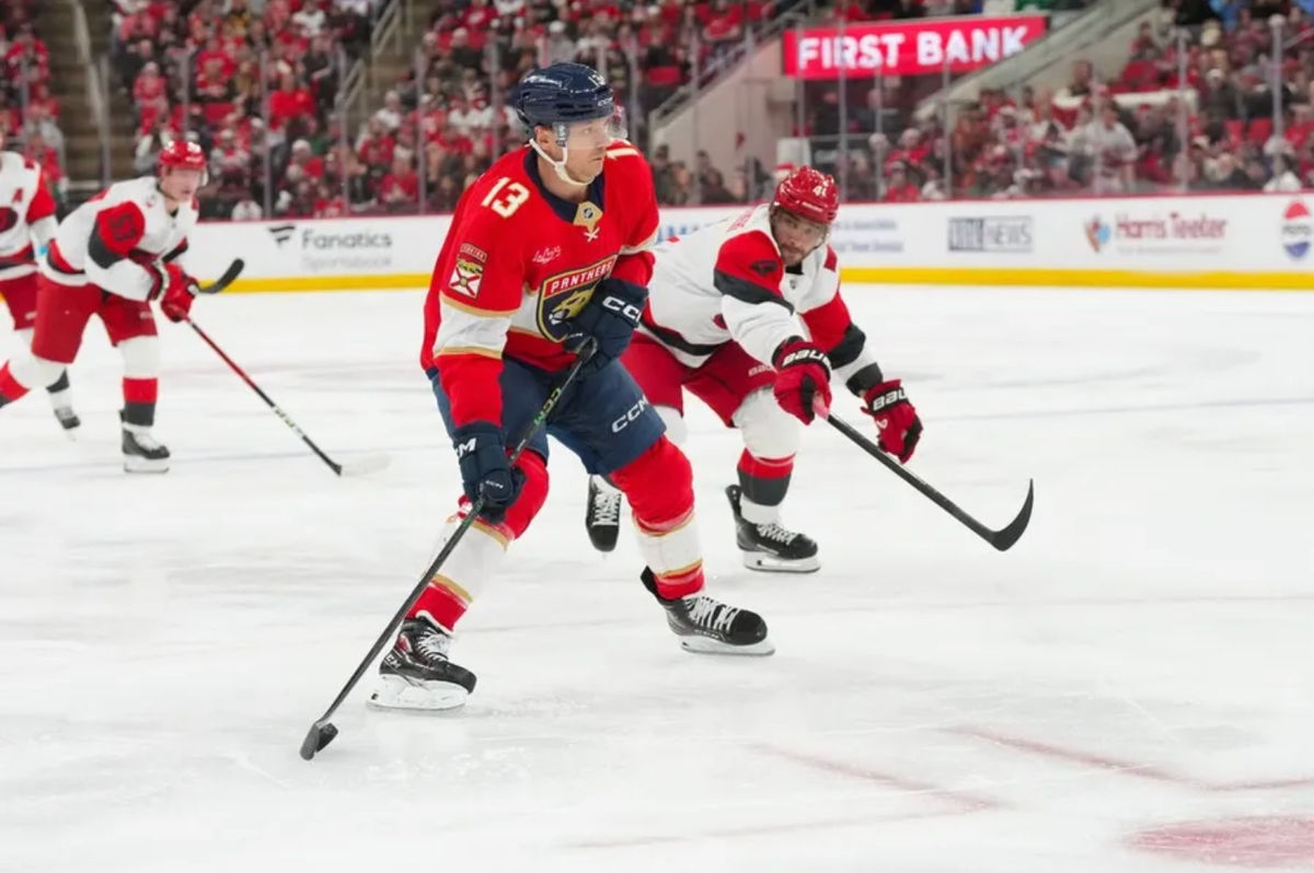 23 de diciembre de 2025; Raleigh, Carolina del Norte, EE. UU.; El centro de los Florida Panthers, Sam Reinhart (13), patina con el disco superando al defensa de los Carolina Hurricanes, Shayne Gostisbehere (4), durante el segundo periodo en el Lenovo Center. Crédito obligatorio: James Guillory-Imagn Images