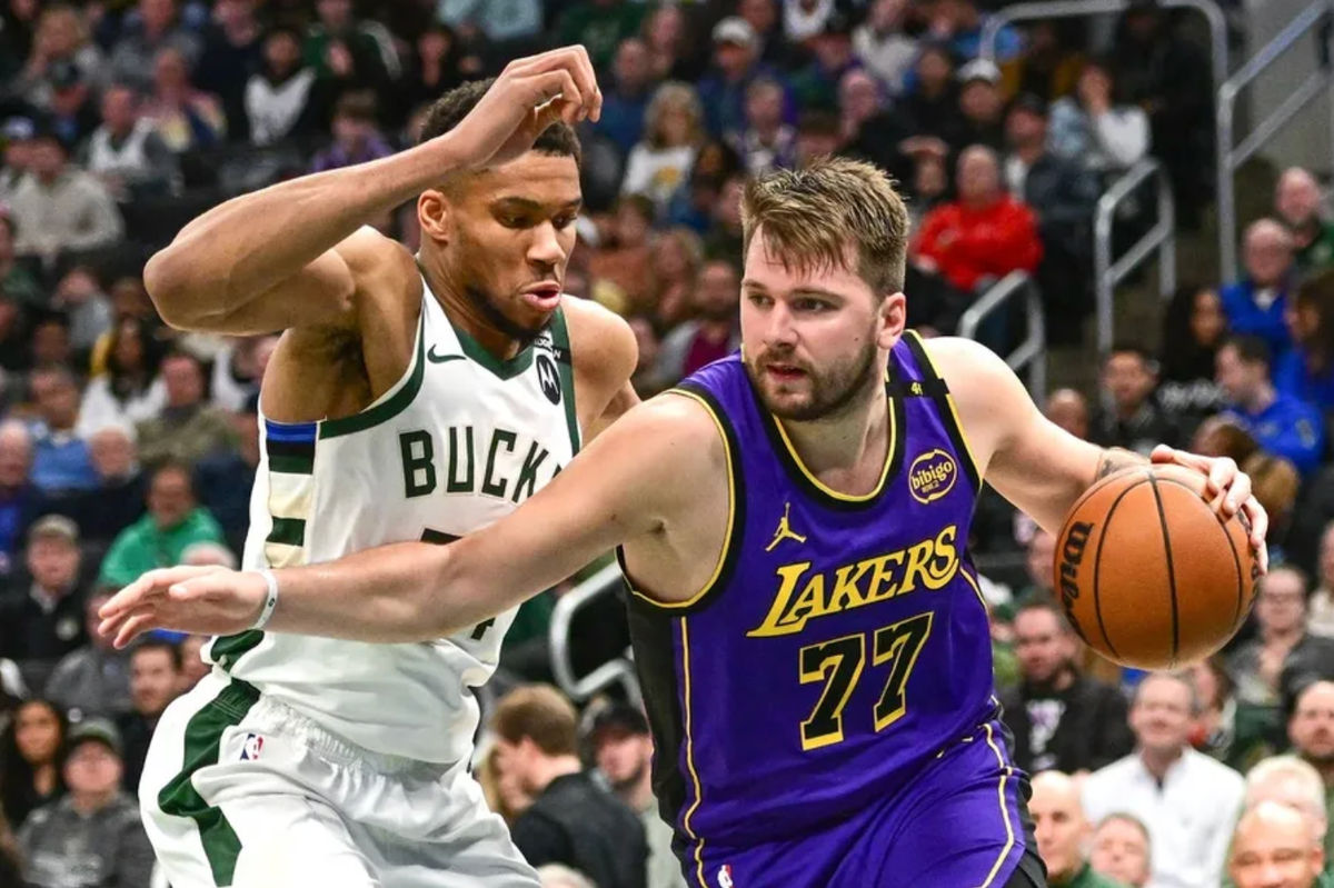 13 de março de 2025; Milwaukee, Wisconsin, EUA; O armador do Los Angeles Lakers, Luka Doncic (77), avança para a cesta contra o ala do Milwaukee Bucks, Giannis Antetokounmpo (34), no terceiro quarto no Fiserv Forum. Crédito obrigatório: Benny Sieu-Imagn Images