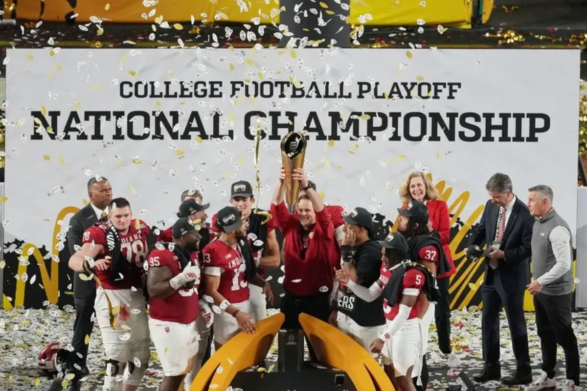 19 de janeiro de 2026; Miami Gardens, Flórida, EUA; O técnico do Indiana Hoosiers, Curt Cignetti, exibe o troféu enquanto a equipe comemora a vitória no Campeonato Nacional de Futebol Americano Universitário no Hard Rock Stadium. Crédito obrigatório: James Lang-Imagn Images