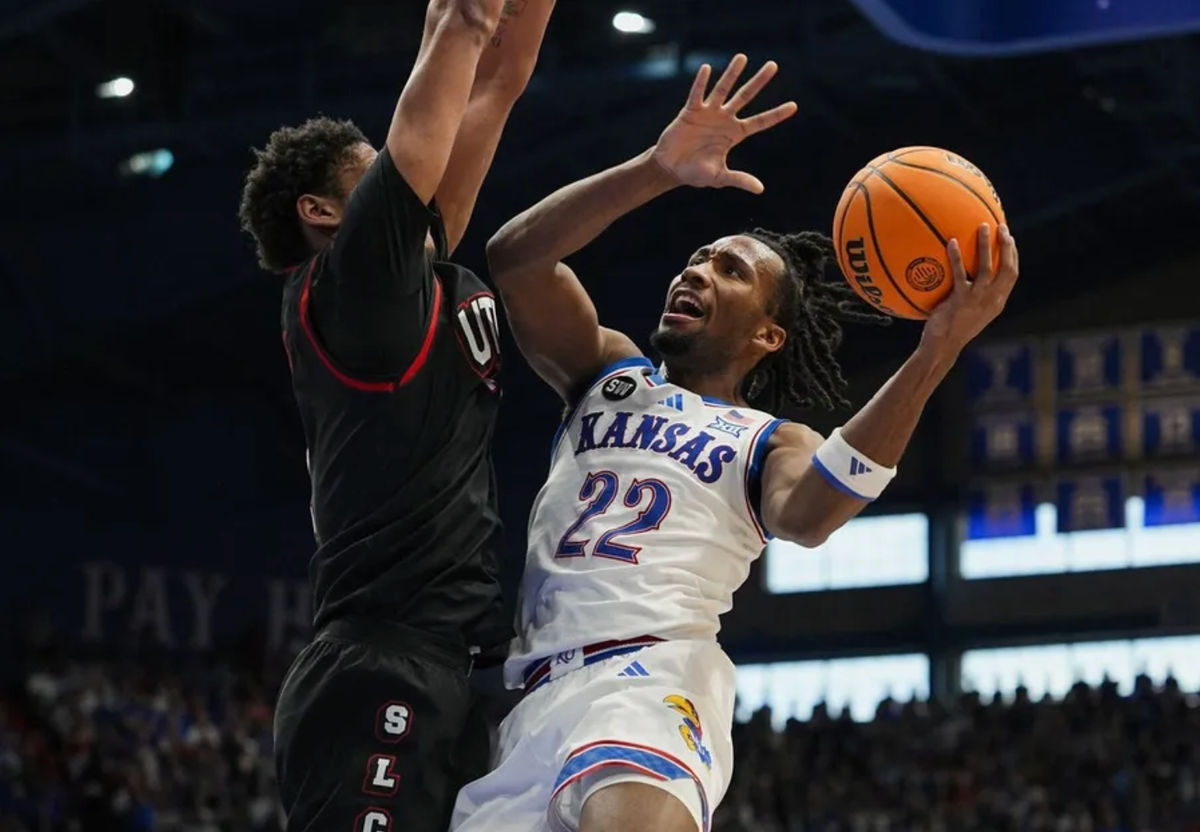 7 de febrero de 2026; Lawrence, Kansas, EE. UU.; El base de los Kansas Jayhawks, Darryn Peterson (22), dispara contra el delantero de los Utah Utes, Josh Hayes (7), durante la segunda mitad en el Allen Fieldhouse. Crédito obligatorio: Jay Biggerstaff-Imagn Images.