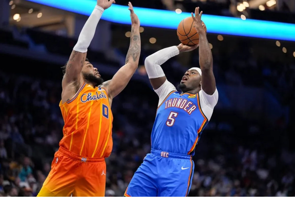 15 de noviembre de 2025; Charlotte, Carolina del Norte, EE. UU.; El base del Oklahoma City Thunder, Luguentz Dort (5), lanza defendido por el alero de los Charlotte Hornets, Miles Bridges (0), durante la segunda mitad en el Spectrum Center. Crédito obligatorio: Jim Dedmon-Imagn Images