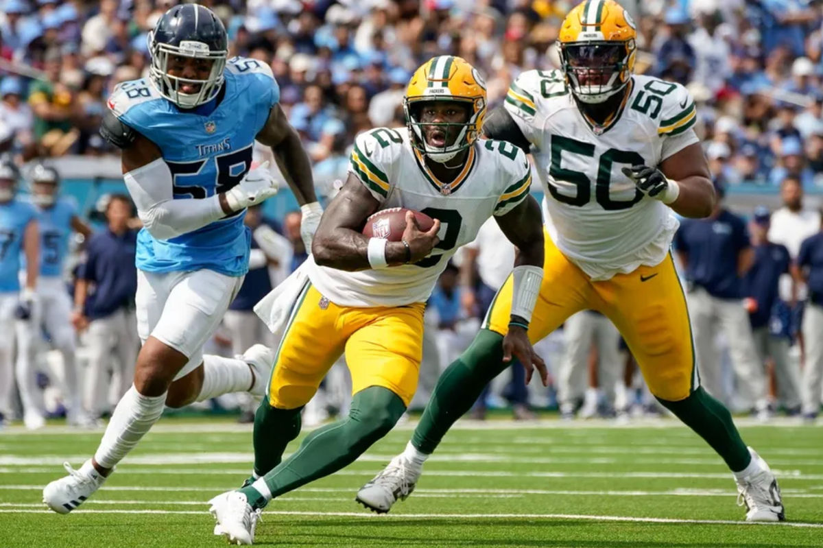 Green Bay Packers quarterback Malik Willis (2) runs the ball past Tennessee Titans linebacker Harold Landry III (58) during the second quarter at Nissan Stadium in Nashville, Tenn., Sunday, Sept. 22, 2024.