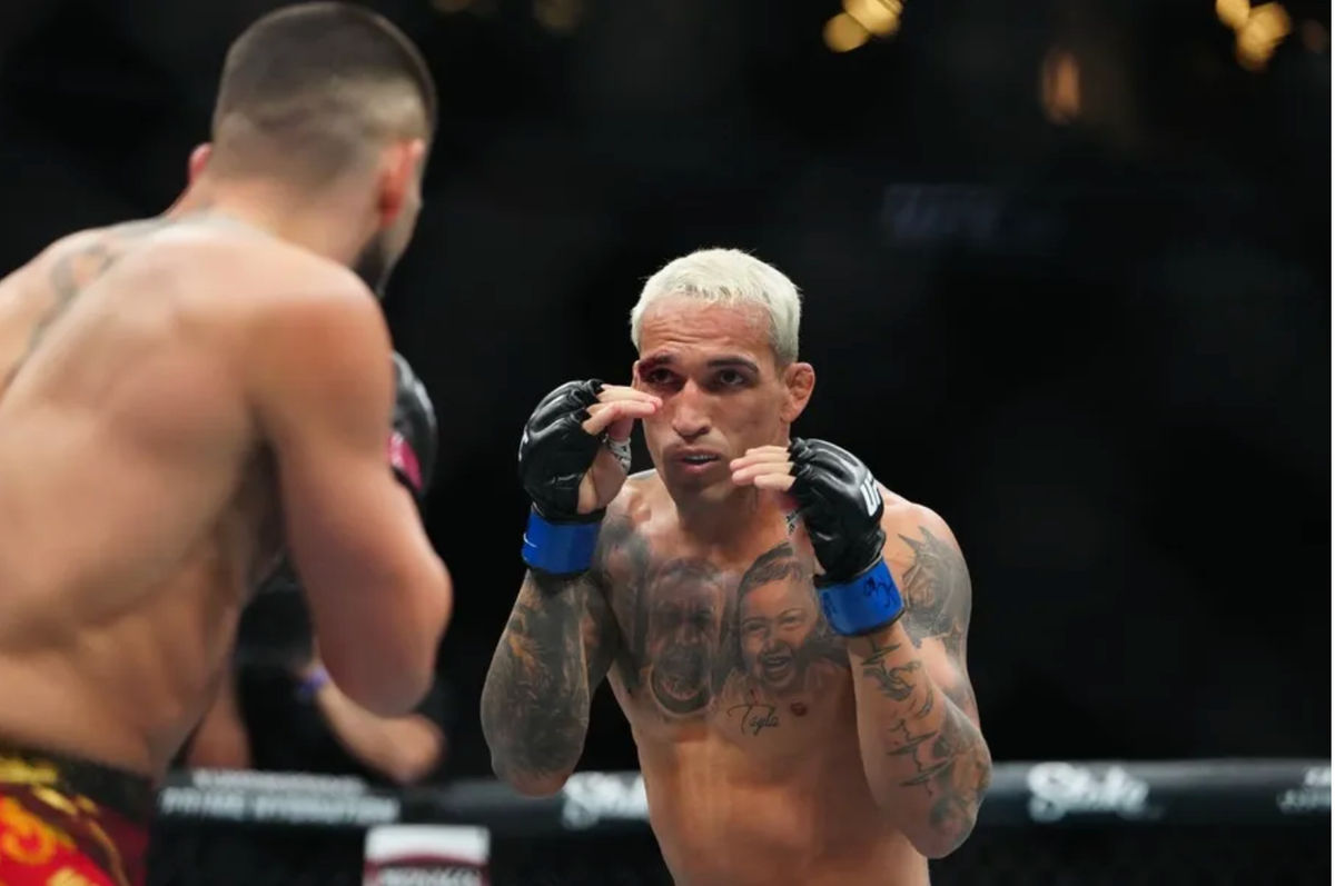 Jun 28, 2025; Las Vegas, Nevada, USA; Ilia Topuria (red gloves) fights Charles Oliveira (blue gloves) during UFC 317 at T-Mobile Arena. Mandatory Credit: Stephen R. Sylvanie-Imagn Images
