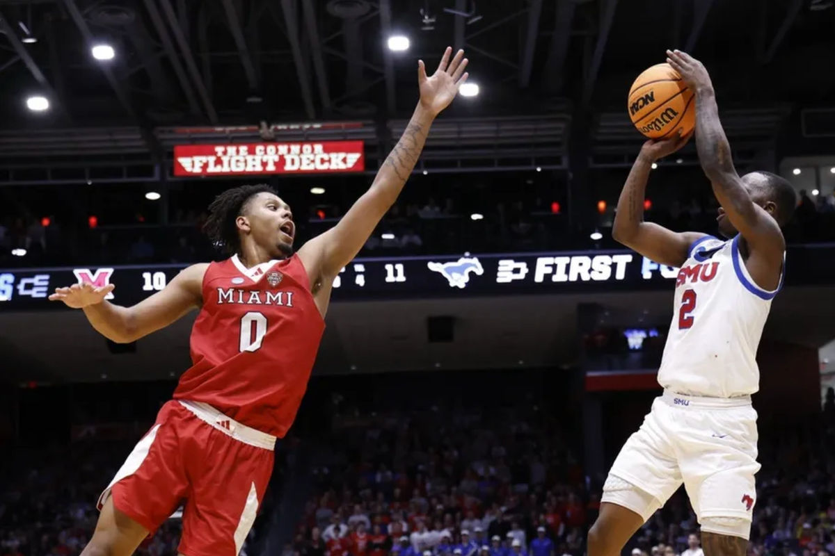 18 de março de 2026; Dayton, OH, EUA; O armador do SMU Mustangs, Boopie Miller (2), arremessa a bola sobre o ala do Miami (OH) RedHawks, Eian Elmer (0), no primeiro tempo da primeira partida da fase de grupos do Torneio da NCAA de 2026, na University of Dayton Arena. Crédito obrigatório: Rick Osentoski-Imagn Images