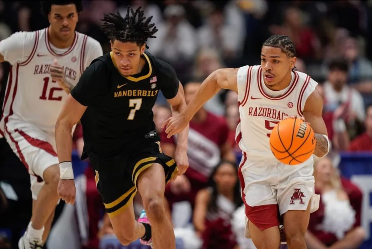 El escolta de Arkansas, Darius Acuff Jr. (5), conduce el balón alrededor del escolta de Vanderbilt, Chandler Bing (7), durante la primera mitad del partido del campeonato del torneo de la SEC en el Bridgestone Arena en Nashville, Tennessee, el domingo 15 de marzo de 2026.