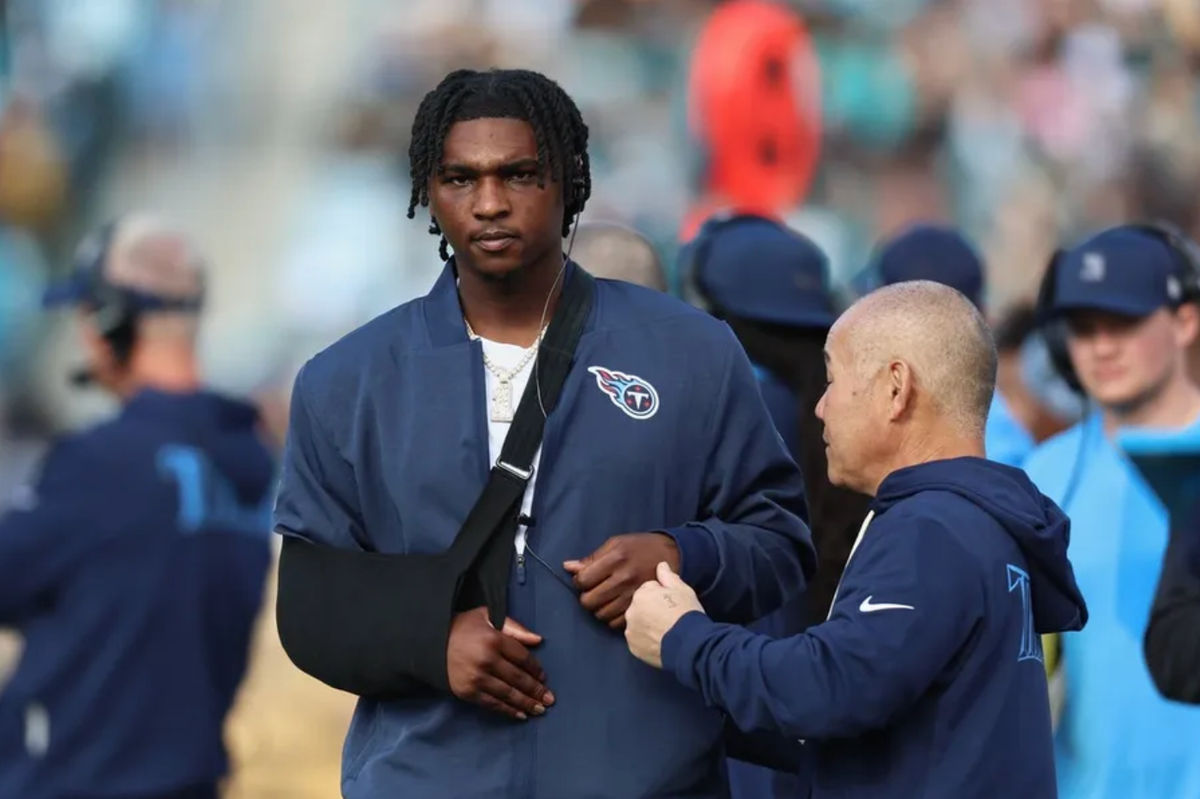 4 de janeiro de 2026; Jacksonville, Flórida, EUA; O quarterback do Tennessee Titans, Cam Ward (1), permanece na lateral do campo com o braço direito imobilizado durante o terceiro quarto, após sofrer uma lesão no ombro contra o Jacksonville Jaguars no primeiro tempo, no EverBank Stadium. Crédito obrigatório: Morgan Tencza-Imagn Images
