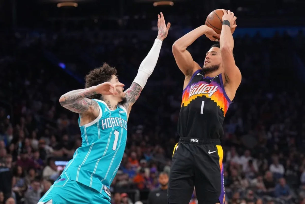 Mar 8, 2026; Phoenix, Arizona, USA; Phoenix Suns guard Devin Booker (1) shoots over Charlotte Hornets guard LaMelo Ball (1) during the second half at Mortgage Matchup Center. Mandatory Credit: Joe Camporeale-Imagn Images