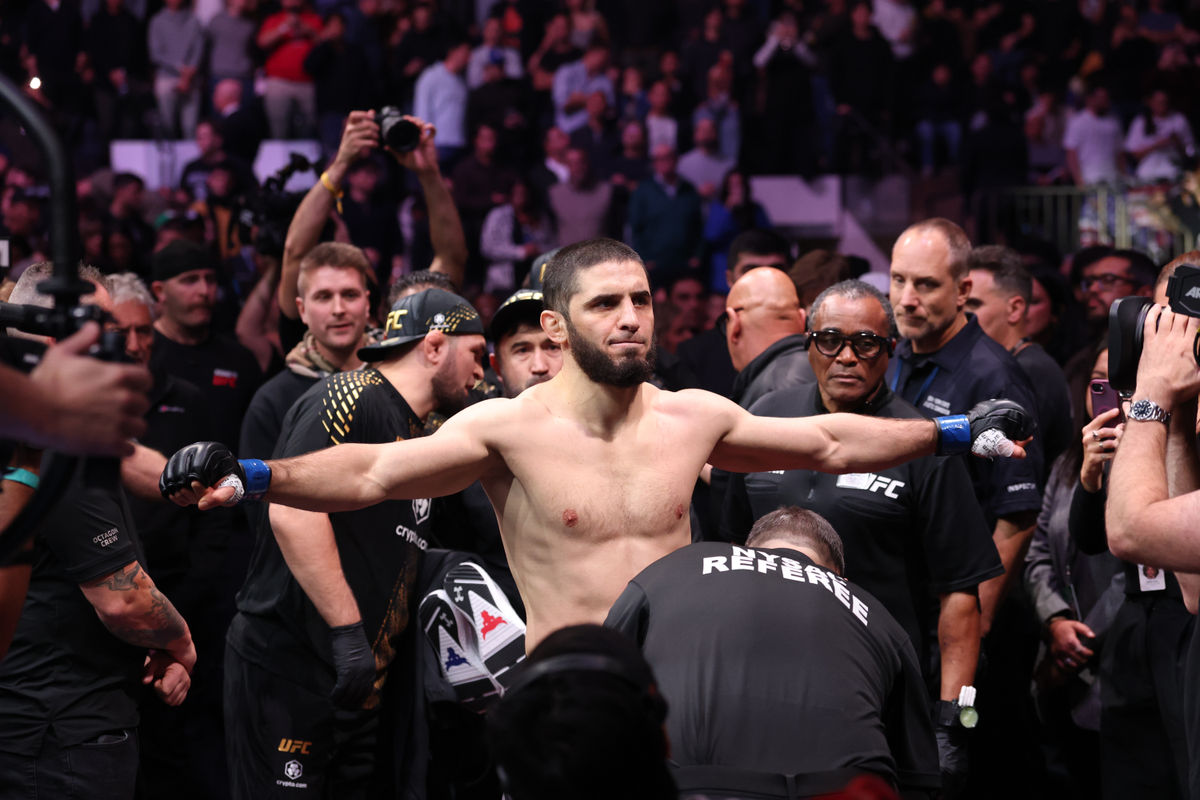 15 de novembro de 2025; Nova York, NY, ESTADOS UNIDOS; Islam Makhachev (luvas azuis) entra no octógono antes da luta pelo cinturão dos meio-médios contra Jack Della Maddalena (não aparece na foto) durante o UFC 322 no Madison Square Garden. Crédito obrigatório: Ed Mulholland-Imagn Images