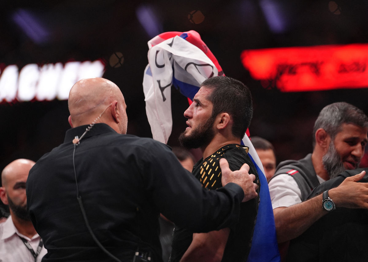 15 de agosto de 2026; Filadélfia, Pensilvânia, EUA; Islam Makhachev (luvas vermelhas) comemora após derrotar Ian Machado Garry (luvas azuis) na disputa pelo título dos meio-médios durante o UFC 330 na Xfinity Mobile Arena. Crédito obrigatório: Kyle Ross-Imagn Images